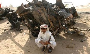Yemenita frente a uno de los vehículos destruidos por el bombardeo de EEUU.