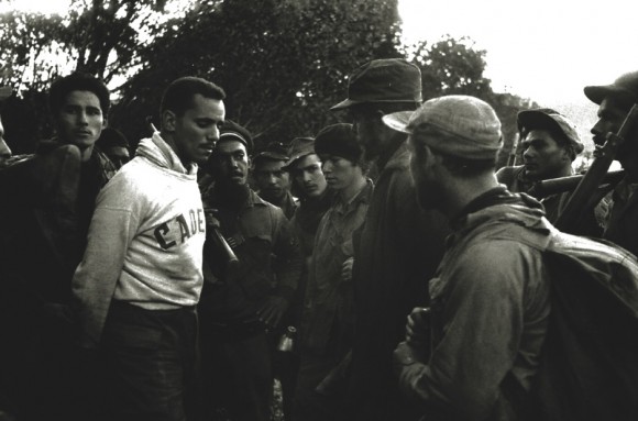 Rodeado por los guerrilleros, el cadete Evelio Laferté, prisionero de las tropas rebeldes, responde a las preguntas del Che.