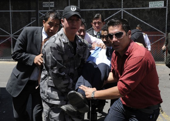 Rafael Correa es cargado del Regimiento Quito luego de ser alcanzado por las bombas de gas. AFP PHOTO / RODRIGO BUENDIA