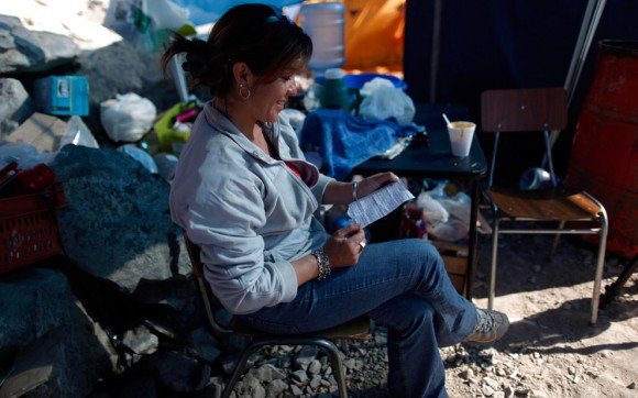 Carola Narváez, esposa de Raúl Bustos, uno de los mineros atrapados en la mina San José, lee una carta de su esposo dirigida,  26 de agosto 2010. Narváez y su esposo también son sobrevivientes del terremoto de febrero en Chile. (Foto AP / Natacha Pisarenko)