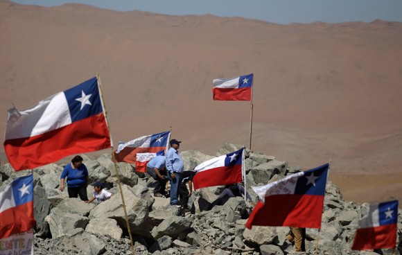 Los familiares de los mineros atrapados conviven entre banderas chilenas fuera de la mina el domingo 29 de agosto 2010. (Foto AP / Roberto Candia)