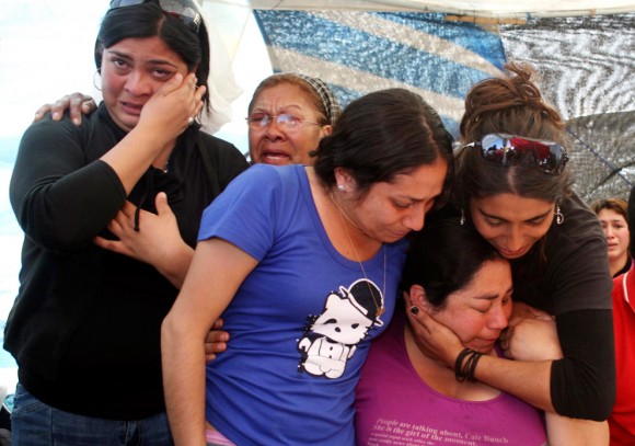 Los familiares de los mineros atrapados reaccionan al enterarse de que los 33 mineros fueron encontrados con vida el 22 de agosto de 2010. (REUTERS / Retamal Hector)