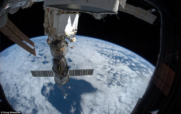 Único momento surrealista en el espacio: Desde la cúpula, una vista de la Soyuz TMA-19 'de Olympus, la nave espacial que llevará a casa el Comandante Wheelock. Las Islas Galápagos se pueden ver a través de una ruptura en las nubes por debajo de