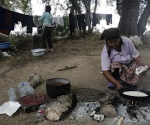 Una mujer rumana calienta en la calle el alimento del día. Foto: Blog Pobreza Mundial