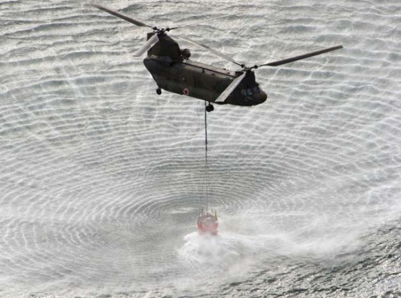 El Helicóptero de la Fuerza Aérea de Japón lleva agua de mar para verter sobre sobre el reactor de Fukushima. Foto: AFP