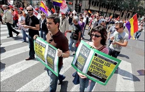 Un hombre y una mujer portan carteles aludiendo a la situación de crisis en la manifestación en Valencia del Día del Trabajo.- EFE/Manuel Bruque