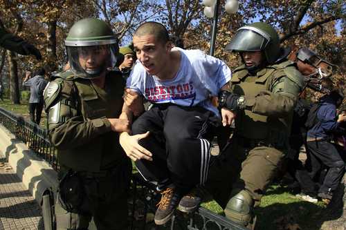 Un estudiante universitario que participaba en las protestas en Santiago es arrestado por miembros de la policía militarizada de Carabineros. Foto: Reuters