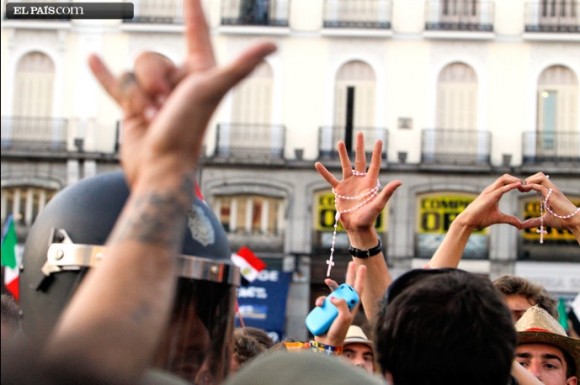 'Cuernos' y crucifijos. Manifestantes y peregrinos se intercambian gestos en la Puerta del Sol, en Madrid.Foto: Carlos Rosillo, El País.