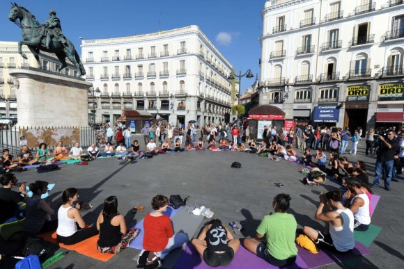 Un grupo de indignados practica yoga en la Puerta del Sol de Madrid en la mañana del 15 de octubre horas antes de las protestas. Foto: AFP