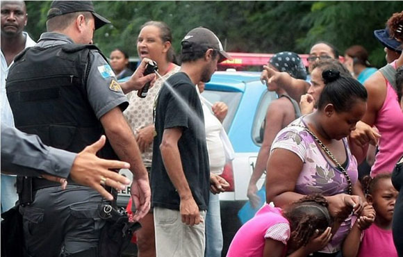 Marzo de 2011. Un policía de Río de Janeiro, Brasil, rocía con spray de pimienta a una niña que acompaña a su madre en una manifestación por las ayudas sociales en la conocida ciudad brasileña. El agente fue expedientado y condenado