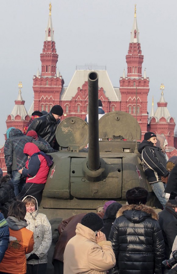 Varias personas subidas en un tanque T-34 soviético de la II Guerra Mundial tras un desfile militar celebrado en la Plaza Roja de Moscú (Rusia) hoy, lunes 7 de noviembre de 2011. El desfile conmemora el 70º aniversario del histórico desfile de 1941 cuando el ejército soviético cruzó por la plaza mientras se dirigía al frente durante la II Guerra Mundial. EFE/Sergei Ilnitsky