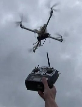 Un piloto prueba un ArduCopter y muestra el radiocontrol frente a la cámara para probar que el aparato se mueve por sí mismo y no está siendo piloteado por un humano. El video puede verse en http://www.youtube.com/watch?v=lYqWWoHpWi4