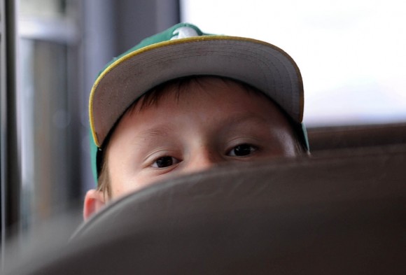 Wiley James Hickman se asoma sobre el asiento de un autobús escolar camino a la escuela en  Reno, Nevada. Este niño no tiene casa. (Foto: Andy Barron / Associated Press / El Reno Gazette-Journal)