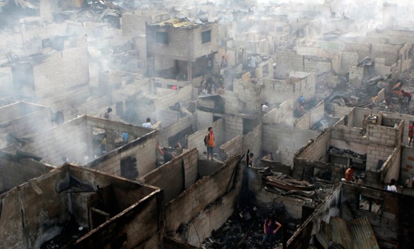 Personas que viven en las ruinas de sus casas después de un incendio en Makati City, en Manila. El incendio arrasó al menos 900 casas precarias dejando a más de 2.000 familias sin hogar, dijo la policía. (Foto: Erik De Castro / Reuters)