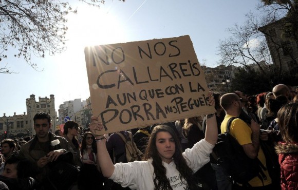 Una joven muestra una pancarta durante la concentración frente al instituto Lluís Vives de Valencia. JOSE JORDAN (AFP)