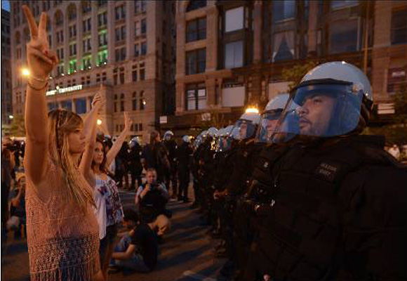 Manifestantes hacen con sus dedos la señal de la victoria mientras protestan contra la cumbre de la OTAN en una calle de Chicago (EEUU). EFE/TANNEN MAURY