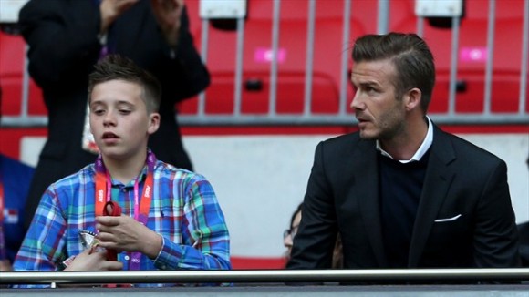 David Beckham y su hijo Brooklyn miran el juego de fútbol entre el Reino Unido y Emiratos Arabes Unidos