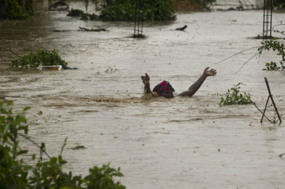 Una mujer pasa una calle inundada en Puerto Príncipe. Foto: AFP