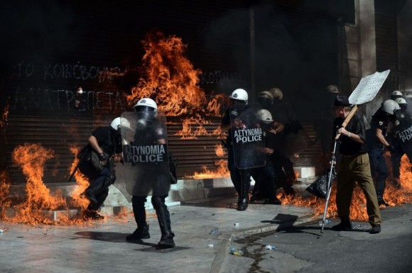 Las botellas incendiarias estallan tras la policía. La marcha que fue pacífica, se vio alterada al final del recorrido por la violencia de jóvenes encapuchados. ARIS MESSINIS (AFP) 