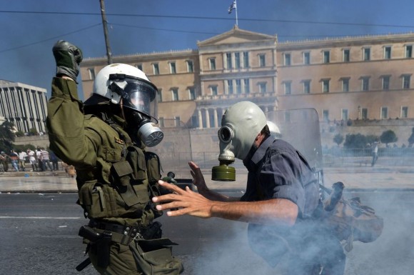  Un manifestante se enfrenta a un policía antidisturbios frente al Parlamento. ARIS MESSINIS (AFP) 