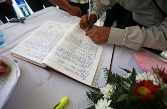 Un hombre firma en un libro en una maratón de bodas masivas en Managua. Foto: Mario Lopez / EFE 