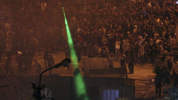 Anti-Mursi protesters throw stones and shine laser pointers at supporters of Egyptian President Mursi, outside the presidential palace in Cairo