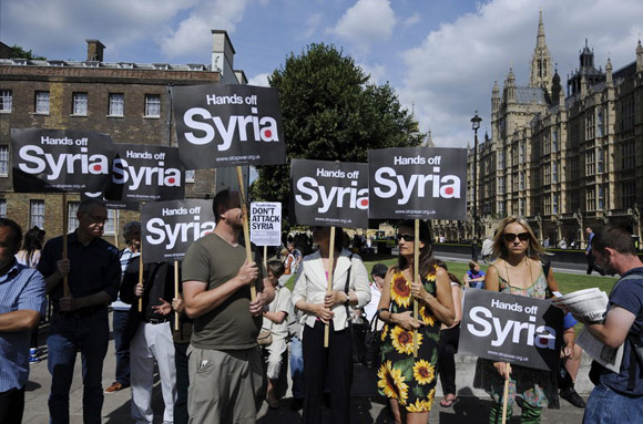 Los militantes pacifistas enarbolaban banderas sirias y pancartas con leyendas como "No al ataque a Siria", "No toquen a Siria"