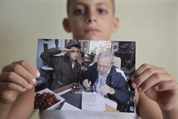 Eight-year-old Marlon Mendez, who claims to be an admirer of Cuba's former president Fidel Castro, shows a book " La Victoria Estrategica" of Fidel Castro dedicated by Castro for him , in San Antonio de los Banos, outside Havana City, August 23, 2014. Cuba's former president Fidel Castro invited him little after he learned about Marlon Mendez who is a bigger admirer from him. REUTERS/Enrique De La Osa (CUBA  - Tags: POLITICS SOCIETY)