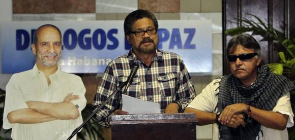 El segundo jefe de las FARC, Iván Márquez (cen.), lee un comunicado junto a una imagen del guerrillero preso en EEUU, Simón Trinidad, el martes en el Palacio de Convenciones de La Habana.Fotos: Alejandro Ernesto/EFE 