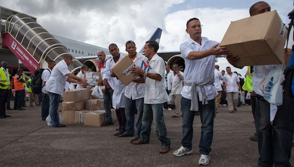 Los primeros miembros de un equipo de 165 médicos cubanos y trabajadores de la salud descargan cajas de medicamentos y material médico de un avión a su llegada al aeropuerto de Freetown para ayudar a la lucha contra el Ébola en Sierra Leona, el 2 de octubre de 2014 FLORIAN PLAUCHEURFLORIAN PLAUCHEUR / AFP / Getty Images