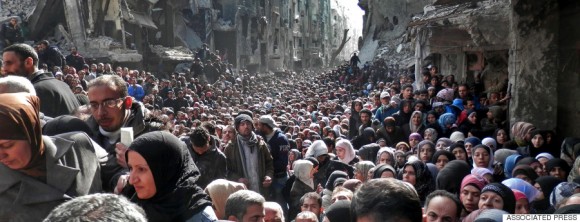 OR USE AS DESIRED, YEAR END PHOTOS - FILE - This picture taken on Jan. 31, 2014, and released by the UNRWA, shows residents of the besieged Palestinian camp of Yarmouk, queuing to receive food supplies, in Damascus, Syria. A United Nations official called on warring sides in Syria to allow aid workers to resume distribution of food and medicine in a besieged Palestinian district of Damascus. The call comes as U.N. Secretary General Ban Ki-Moon urged Syrian government to authorize more humanitarian staff to work inside the country, devastated by its 3-year-old conflict. (AP Photo/UNRWA, File)