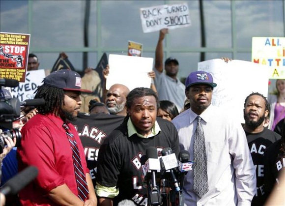 Muhiyidin D'baha (c) portavoz del moviemiento Black Lives Matters se dirige este 8 de abril a los medios durante la manifiestación en frente del Ayuntamiento de North Charleston en Carolina del Sur, EE.UU.