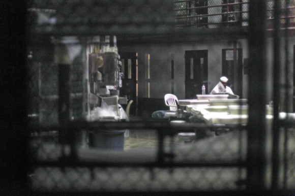 Un prisionero no identificado lee un periódico en un pabellón comunitario en el Camp VI, una prisión utiliza para los detenidos de las casas de Estados Unidos en Guantánamo Base Naval, 05 de marzo 2013. Bob Strong