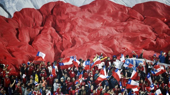 Fanáticos de Chile despliegan una bandera gigante sobre la tribuna durante el partido entre su equipo y Uruguay, por los cuartos de final de la Copa América, en Santiago. Chile ganó 1 a 0 y consiguió el pase a las semifinales. Foto: AP