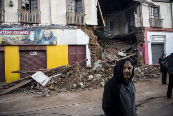 Un hombre pasa frente a una casa completamente destruída por el terremoto. Foto: Getty Images.