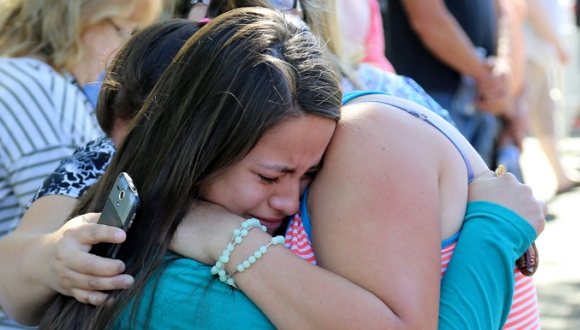 Familiares y amigos se consuelan entre sí luego de la tragedia. Foto: AP.