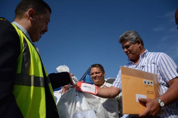 Carlos Gutierrez, inspector de seguridad postal del correo de EEUU, entrega la carta que reinaugura el servicio directo entre los dos países. Foto: Jorge Legañoa/ ACN